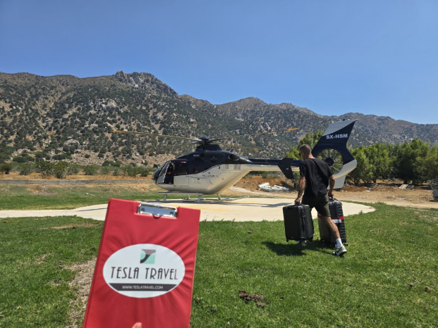 Tesla Travel Mykonos Bodrum helicopter transfer with private helicopter landing and passenger carrying luggage for VIP island transfer
