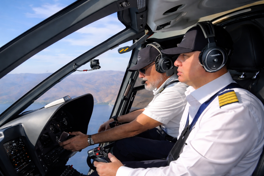 Professional helicopter pilot and passenger flying over Greek islands Aegean Sea private charter transfer from Kos