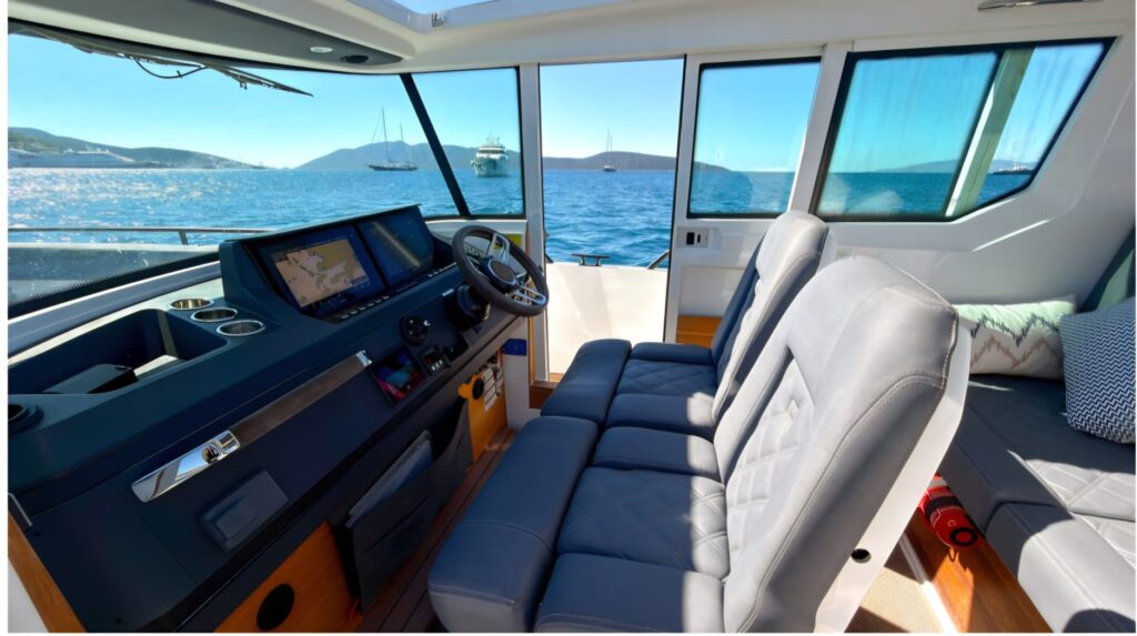 Axopar 28 Bodrum Indoor luxury cabin interior with premium leather seating, panoramic glass windows, modern Scandinavian design, sliding roof, and comfortable VIP seating area designed for fast Bodrum to Kos speedboat transfers and Greek island luxury transportation.